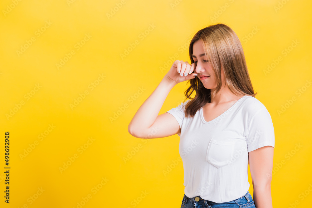 Asian Thai portrait beautiful cute young woman in depressed bad mood her cry wipe tears with fingers, studio shot isolated on yellow background with copy space Asian Thai portrait beautiful cute young woman in depressed bad mood her cry wipe tears with fingers, studio shot isolated on yellow background with copy space