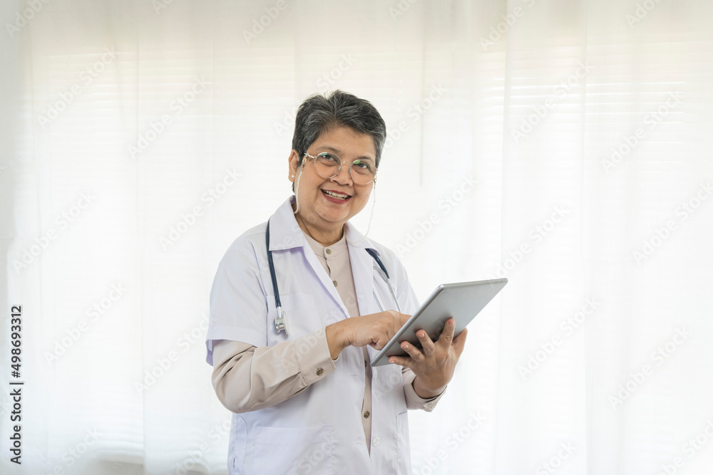 Confident senior female doctor happy using tablet computer standing in clinic. Confident senior female doctor happy using tablet computer standing in clinic.