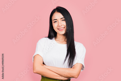 Asian happy portrait beautiful cute young woman standing her smile confidence with crossed arms isolated, studio shot on pink background and copy space, Thai female looking to camera © sorapop