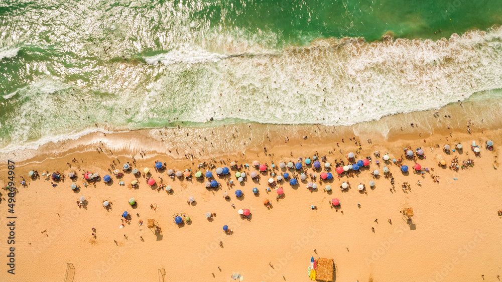 Aerial view top view drone of Beach showing colourful umbrellas and people relaxing on a summer day. Aerial view top view drone of Beach showing colourful umbrellas and people relaxing on a summer day.