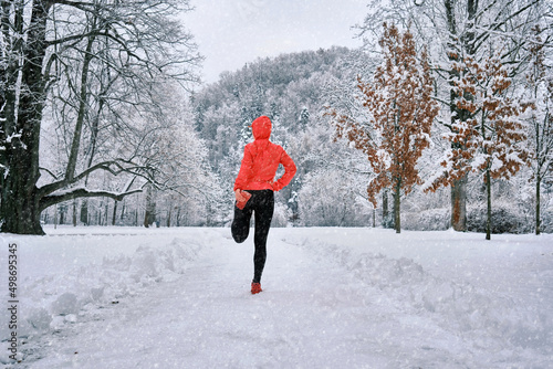 Fototapeta Naklejka Na Ścianę i Meble -  Running woman, girl runner on snow in park in winter sunny day.