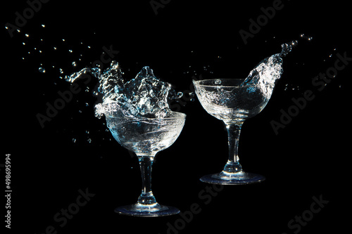 Big splash of liquid pouring from two wine glass