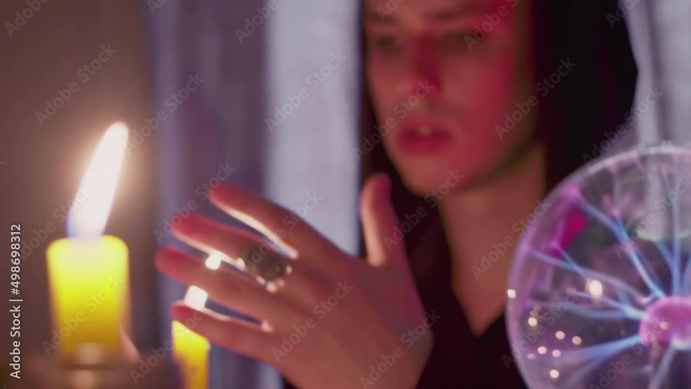 Side view of male fortune teller moving hands above the magic candle Side view of male fortune teller moving hands above the magic candle
