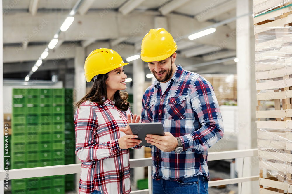 The controllers looking at checklist on tablet while standing in factory. The controllers looking at checklist on tablet while standing in factory.