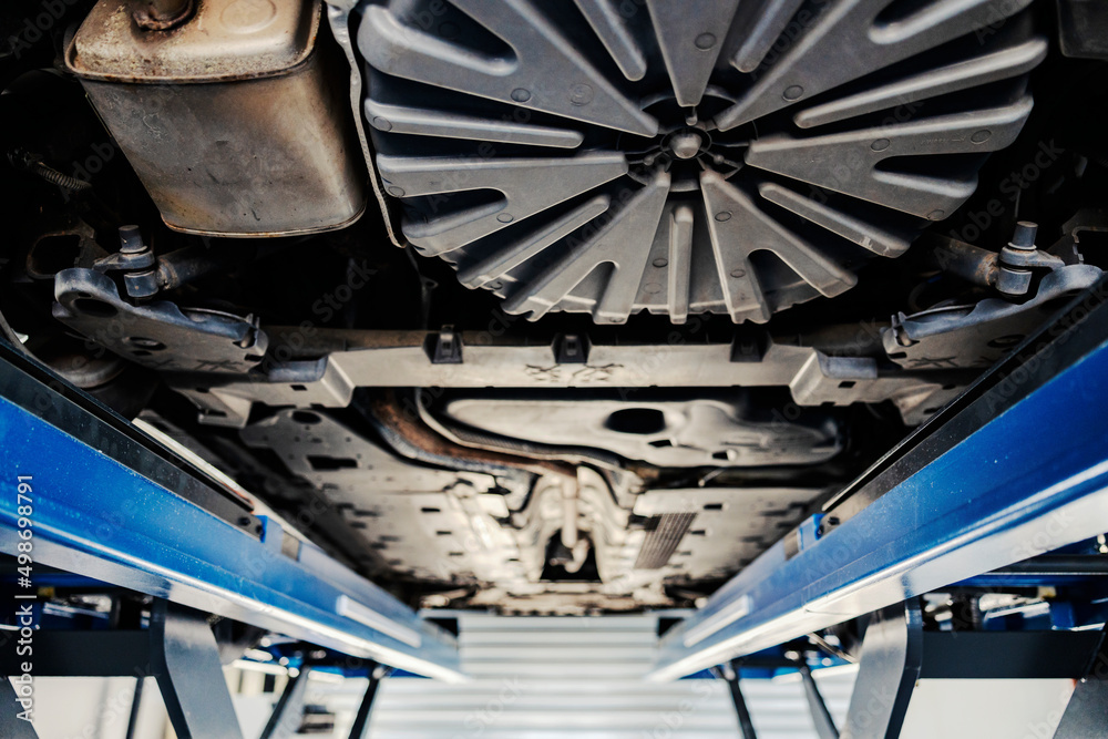 A lifted car and under it at mechanic's shop.. A lifted car and under it at mechanic's shop..