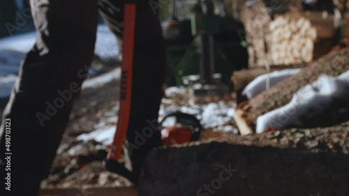 Man Prepares to Chop Logs into Firewood for the Winter photo