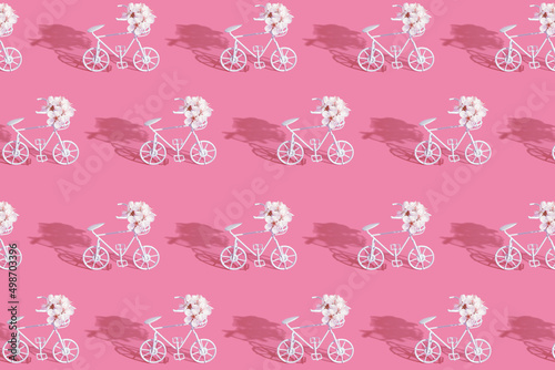 Patternn with decorative bicycles with flowers on pink background photo