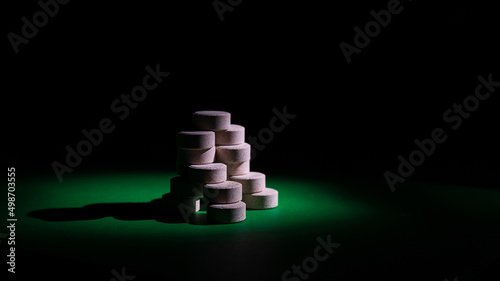 dietary supplements low key selective focus copy space. DGL (licorice root extract) chewable tablets isometric view. wellbeing and personal health care concept side view photo