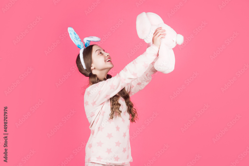 happy easter kid girl in bunny rabbit ears and pajamas play with toy, happy easter