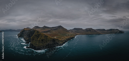 Flying a drone high above the Atlantic Ocean to capture the enormous cliffs of the Faroe Islands at Nordradalur. Streymoy island, november 2021. Panoramic view