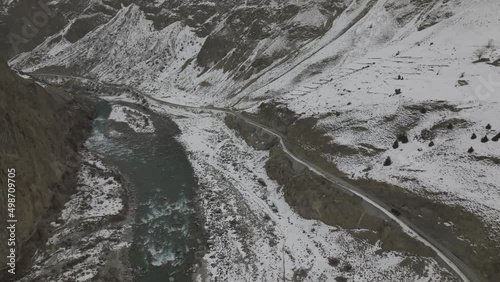 Aerial View Of Karakoram Highway Near Khunjerab Pass, Hunza Valley, Pakistan - drone shot. Aerial Flying Over Altit Fort In Hunza Valley From Over River Dolly Back photo