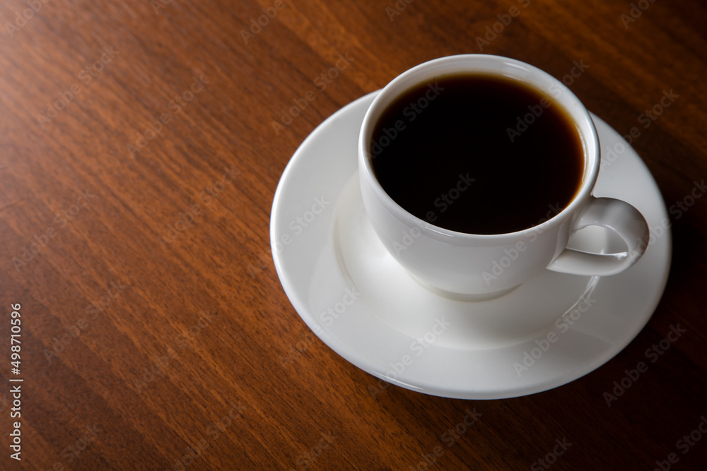 White cup of coffee on wooden background