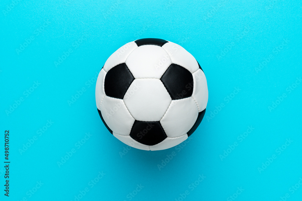 Top view photo of white and black soccer ball as football concept . Minimalist flat lay image of leather football ball over blue turquoise background with copy space and right side composition. Top view photo of white and black soccer ball as football concept . Minimalist flat lay image of leather football ball over blue turquoise background with copy space and right side composition.
