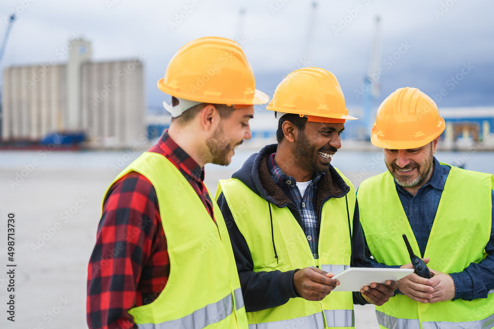 Workers controlling shipping containers at industrial port outdoor using tablet - Focus on indian man face Workers controlling shipping containers at industrial port outdoor using tablet - Focus on indian man face