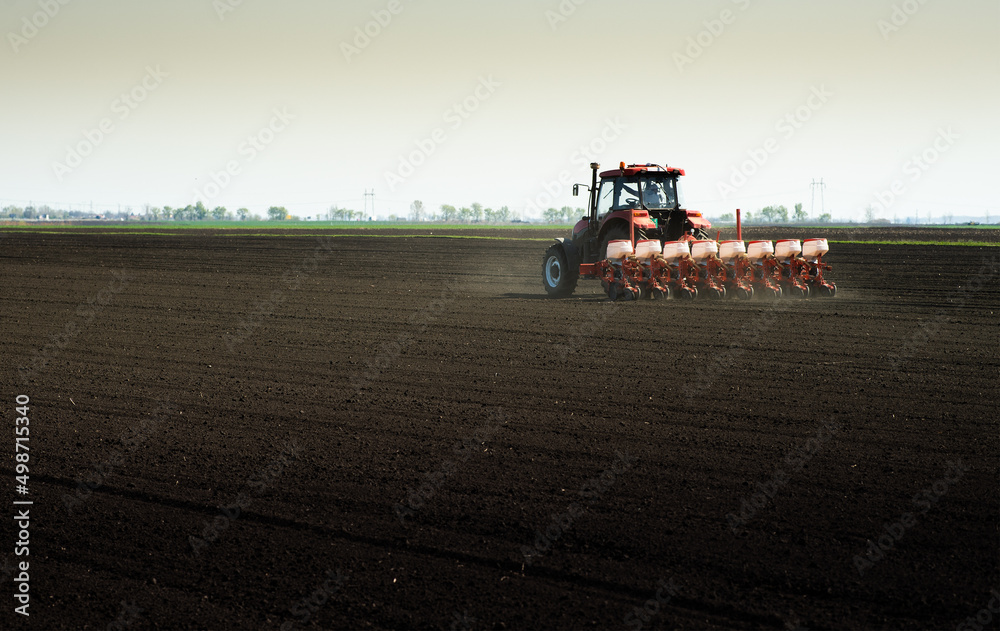 Fototapeta premium Tractor and seeder for sowing corn