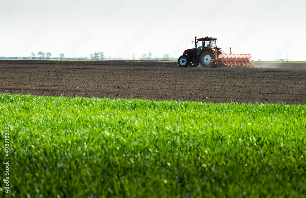 Fototapeta premium Tractor and seeder for sowing corn