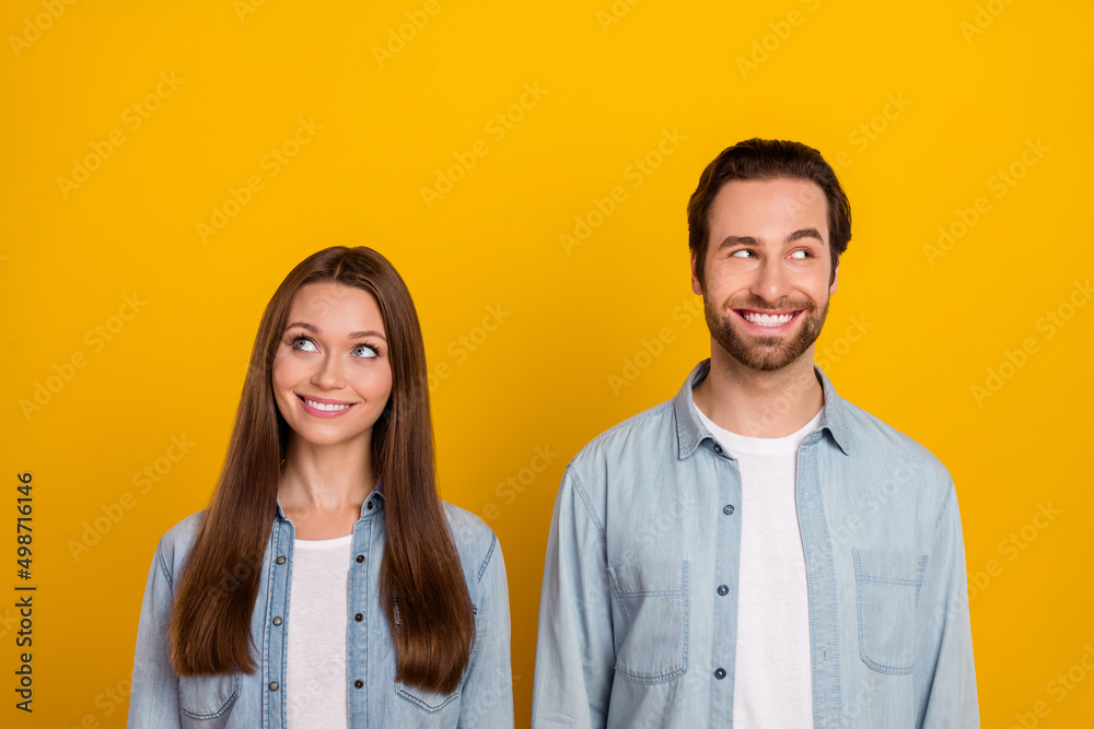 Photo of confident dreamy sister brother dressed denim shirts looking empty space isolated yellow color background Photo of confident dreamy sister brother dressed denim shirts looking empty space isolated yellow color background
