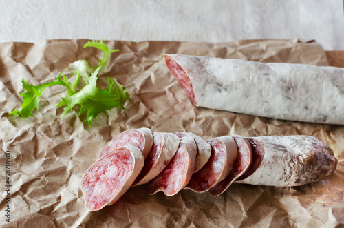 Traditional Catalan thin sausage - fuet. Pieces Pork sausage with mold on craft paper. Horizontal orientation. photo