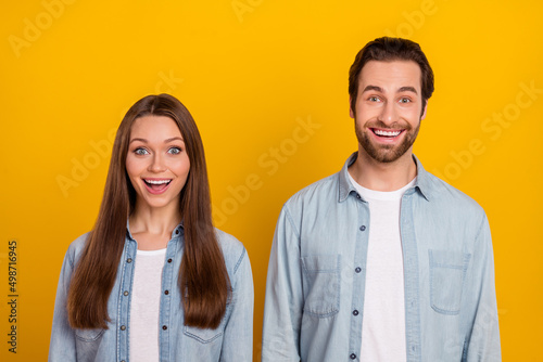 Photo of excited funky sister brother dressed denim shirts open mouth isolated yellow color background