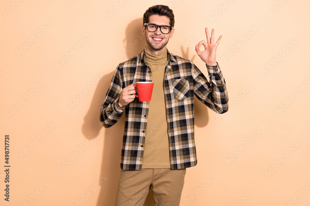 Photo of positive guy manager relax coffee break make okay hand symbol isolated pastel color background Photo of positive guy manager relax coffee break make okay hand symbol isolated pastel color background