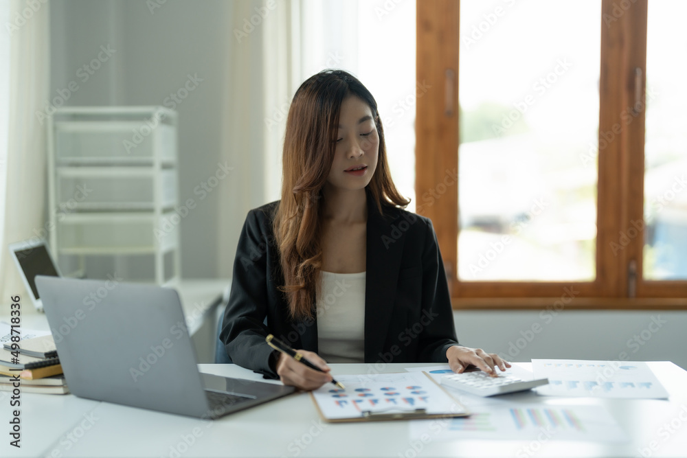 business woman working on desk office with a calculator to calculate the numbers, finance accounting concept business woman working on desk office with a calculator to calculate the numbers, finance accounting concept