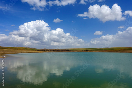 wonderful spring landscape of sky lake and clouds clouds reflecting in water 