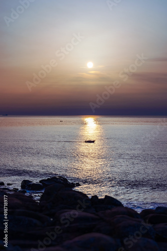 Silhouette of small boat on the Atlantic ocean during sunset