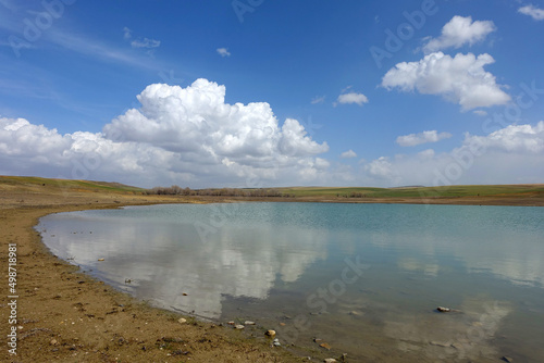 wonderful spring landscape of sky lake and clouds clouds reflecting in water 