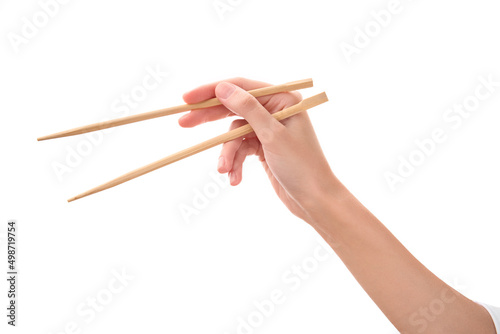 female hand holds Wooden chopsticks isolated on white background. photo