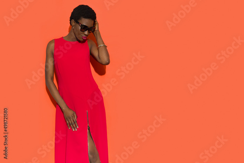 Beautiful black woman in red long dress and sunglasses.