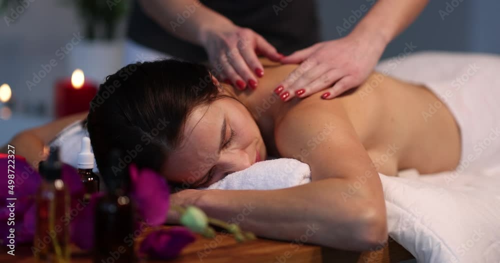 Masseuse makes back massage to woman in spa salon Masseuse makes back massage to woman in spa salon