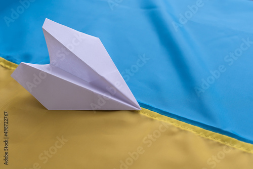 paper airplane on the background of the flag of Ukraine © Angelov