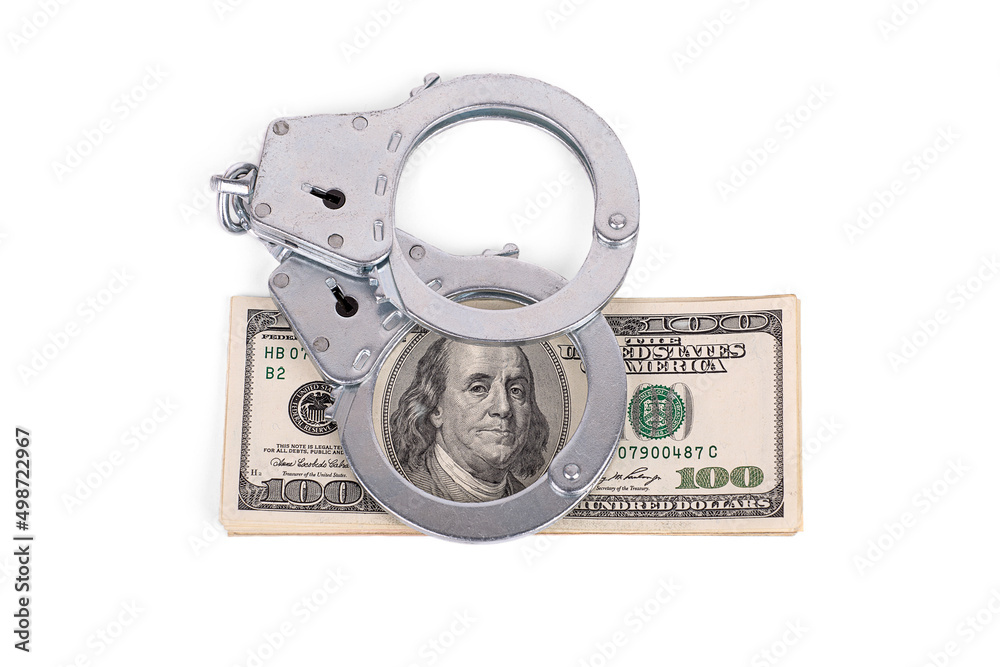 handcuffs lying on a wad of dollars. Benjamin Franklin in the ring. isolated on a white background handcuffs lying on a wad of dollars. Benjamin Franklin in the ring. isolated on a white background