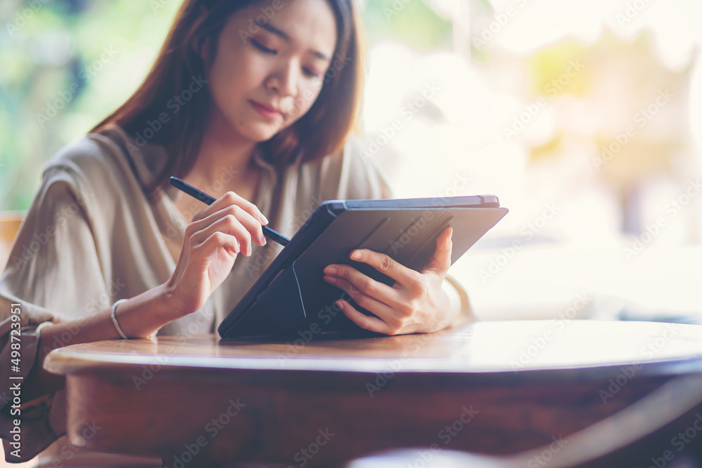 Woman using digital tablet computer at workplace. Businesswoman hand holding pen and touching screen of tablet device. Woman using digital tablet computer at workplace. Businesswoman hand holding pen and touching screen of tablet device.