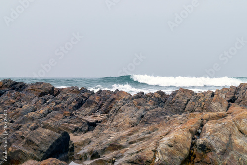 Ocean waves energy, breaking waves. Surfing waves, swell and wave direction. On shore view to ocean waves breaking. Ocean coast backgrounds. 