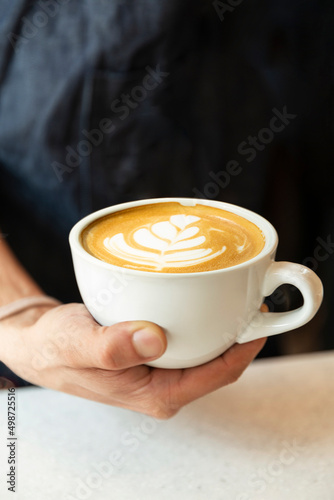 barista holding cup of coffee