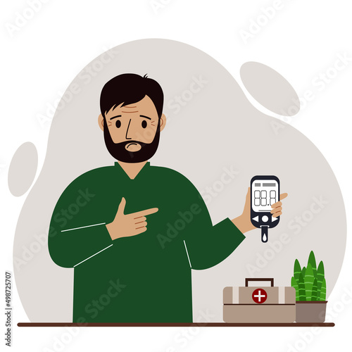 Sad man holds a glucometer in his hand. The concept of blood sugar control, diabetic.