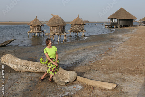 Fashion woman, girl in Senegal, Africa. Lodge Les Collines De Niassam. Tourist woman and Africa nature, landscape, scenery. Senegalese landmark, houses. Tourism, travel in Senegal, Africa. Palmarin photo