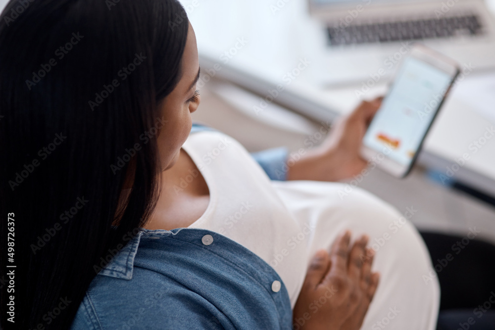 This app has helped me make this permanence is memorable one. Shot of a pregnant woman using her cellphone while sitting at home. This app has helped me make this permanence is memorable one. Shot of a pregnant woman using her cellphone while sitting at home.