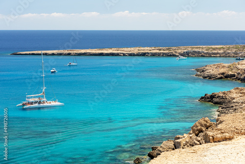 Amazing crystal waters of Blue lagoon with the people and boats at the summer sunny day, island of Cyprus.