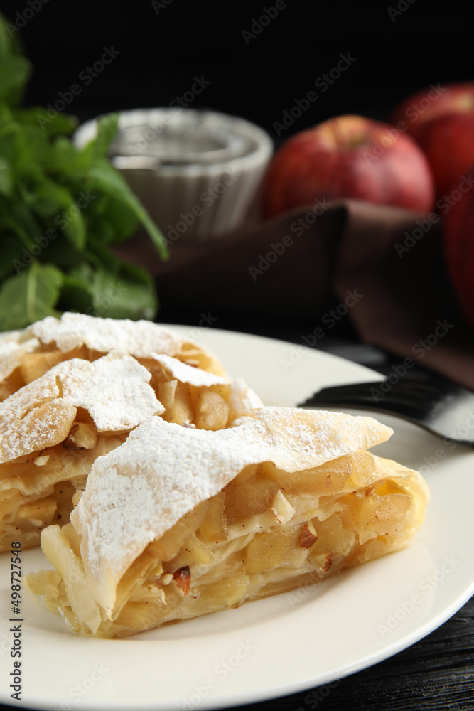 Delicious apple strudel with almonds and powdered sugar on plate, closeup. Space for text Delicious apple strudel with almonds and powdered sugar on plate, closeup. Space for text
