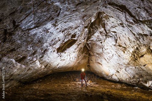 Foto Woman inside the cave standing in underground gallery