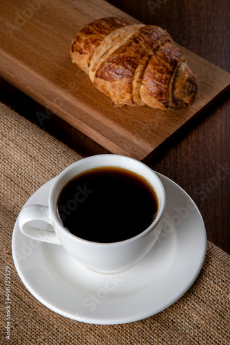 Croissant with a cup of full coffee,directly above	