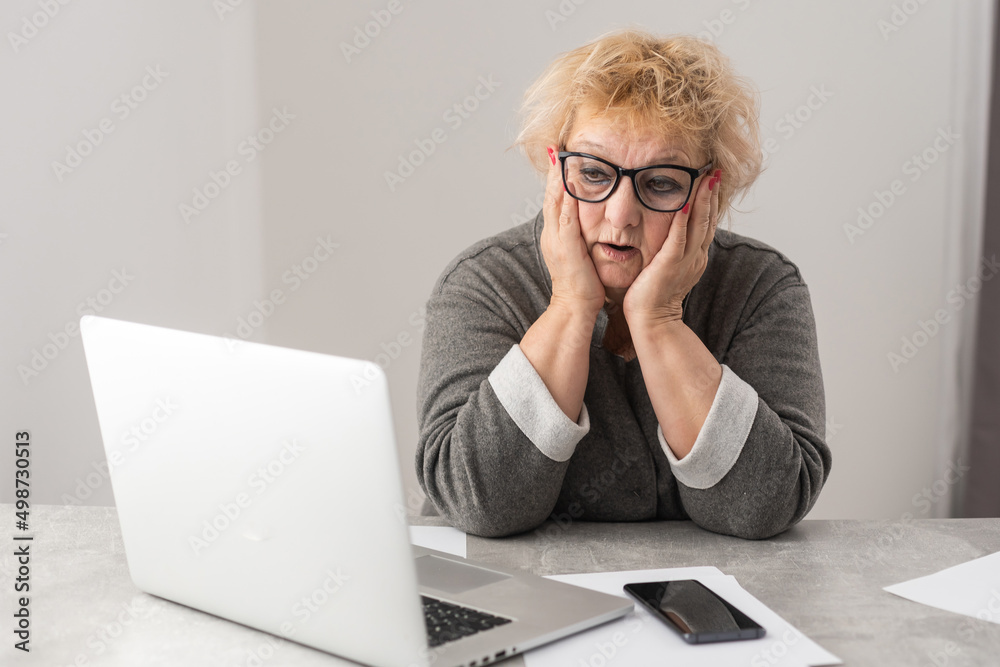 Retired woman calculating her domestic bills Retired woman calculating her domestic bills