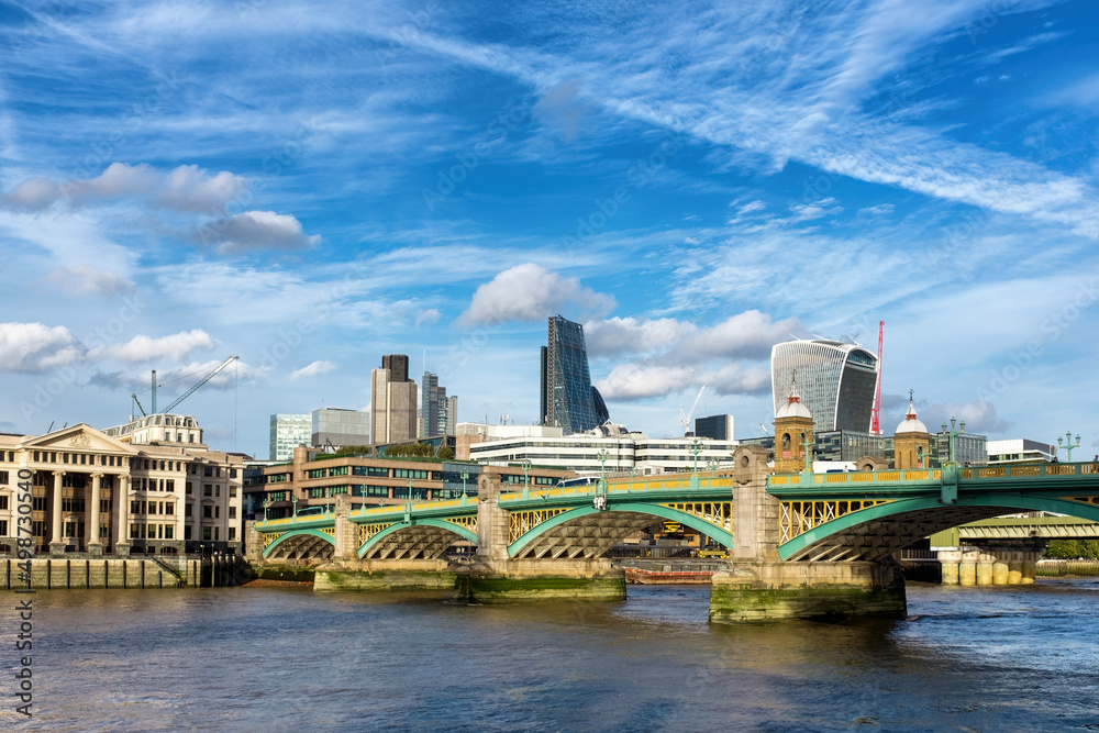 Obraz premium Southwark Bridge spanning the river Thames, with the City of London financial district in the background.