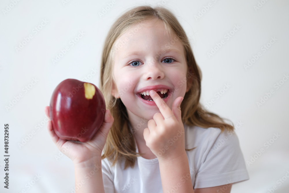 Smiling girl without tooth is holding apple Smiling girl without tooth is holding apple