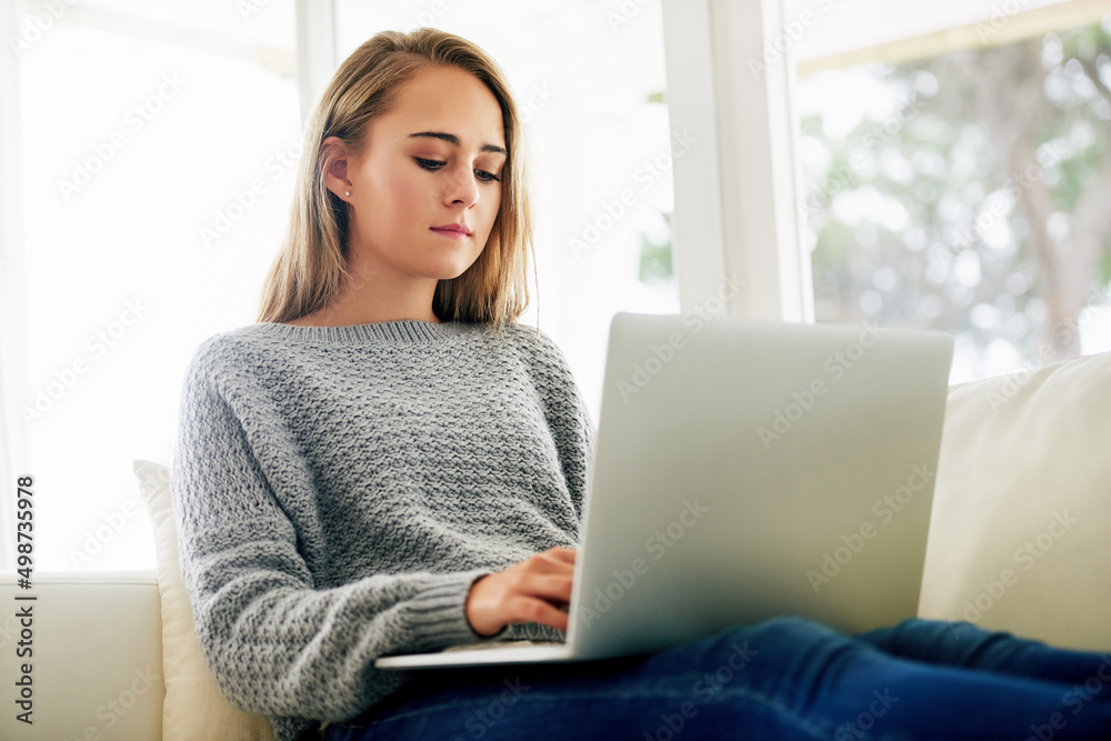 Naklejka premium Blogging his her new favourite hobby. Cropped shot of an attractive young woman using her laptop while chilling at home.