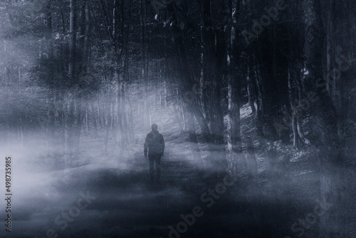 silhouette of a man walking in the woods at night