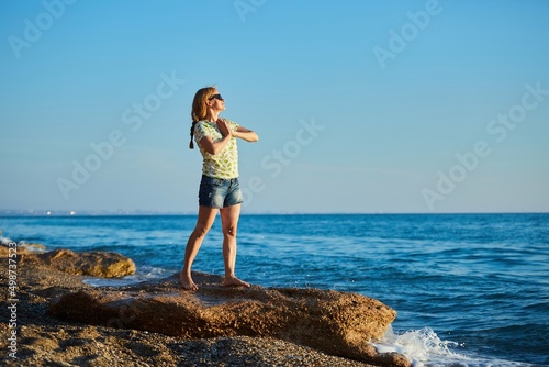 A girl on the seashore at sunset. Relaxation and enjoyment of nature.