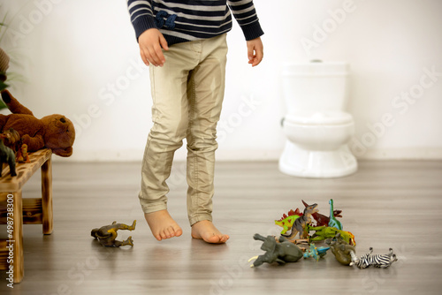 Little toddler child, boy, pee in his pants while playing with toys, child distracted and forget to go to the toilet